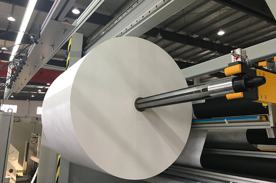 How does a plastic film slitter ensure the synchronization between the layers of multi-layer films?
